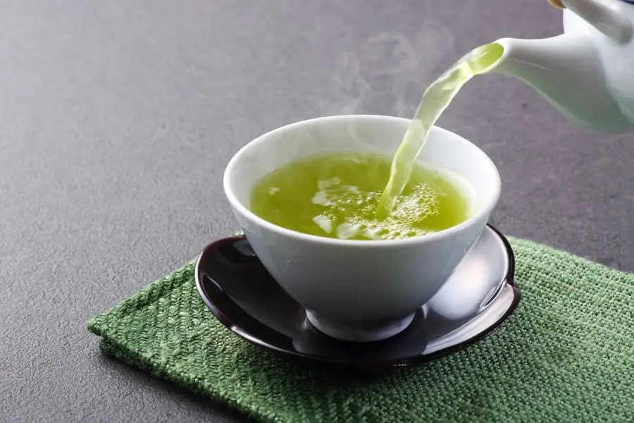 Verter té verde en una taza